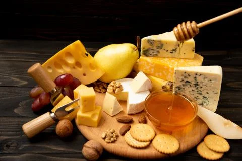 Various types of cheese on a rustic table Stock Photos