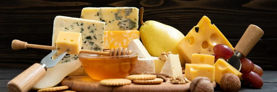 Various types of cheese on a rustic table Stock Photos