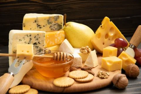Various types of cheese on a rustic table Stock Photos