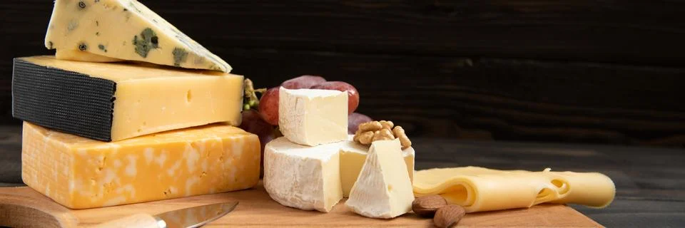 Various types of cheese on a rustic table Foto stock