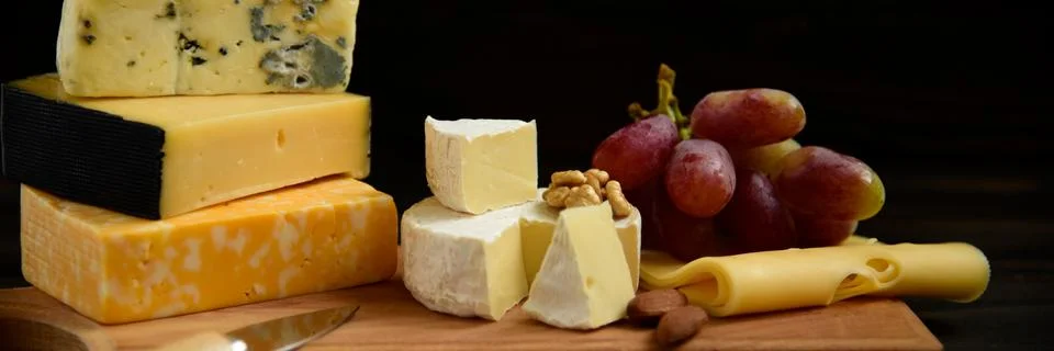 Various types of cheese on a rustic table Foto stock