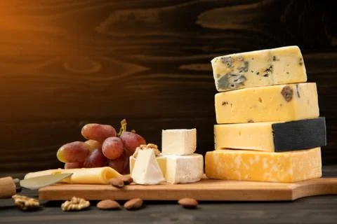 Various types of cheese on a rustic table Stock Photos