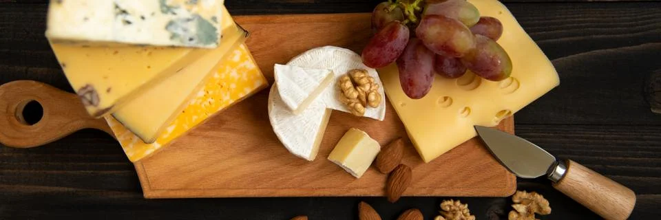 Various types of cheese on a rustic table Stock Photos