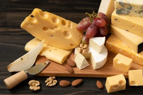 Various types of cheese on a rustic table Stock Photos