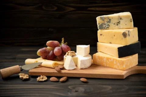 Various types of cheese on a rustic table Stock Photos