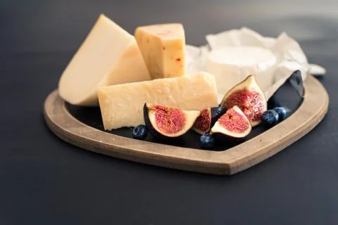 Various types of cheese on rustic wooden table, goat cheese, chevre, grana Stockfoto's