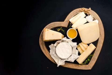 Various types of cheese on rustic wooden table, goat cheese, chevre, grana pa Foto stock
