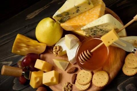 Various types of cheese on a rustic wooden table Stock Photos