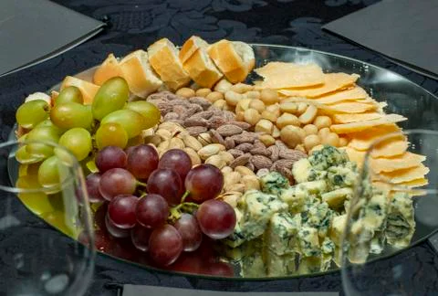 Various types of cheese set with grapes and nuts. Stock Photos