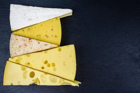 Various types of cheese on a slate board. Top view Stock Photos