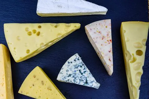 Various types of cheese on a slate board. Top view Stock Photos