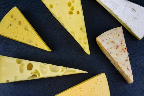 Various types of cheese on a slate board. Top view Stock Photos