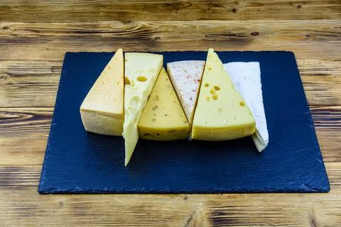 Various types of cheese on a slate board 库存照片