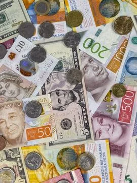 Various types of currency spread out on a flat surface in bright light Stock Photos