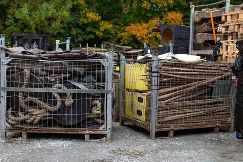 Various types of discarded materials stored in metal cages at a recycling Foto stock