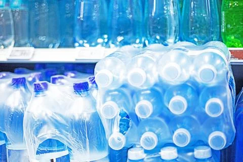 Various types of drinking water in plastic bottles in a package at the supe.. Stock Photos