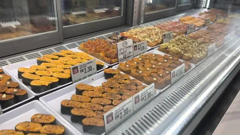 Various Types of Fresh Sushi Displayed for Sale Behind Glass Stock Footage 321040092