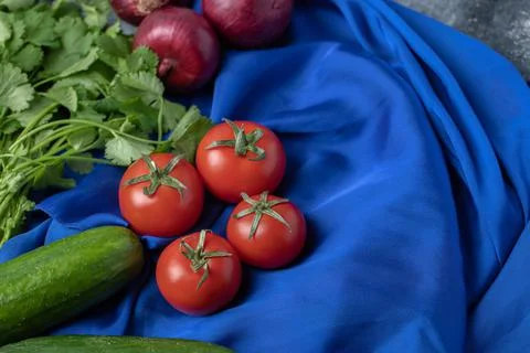 Various types of fresh vegetables on blue tablecloth Stock Photos
