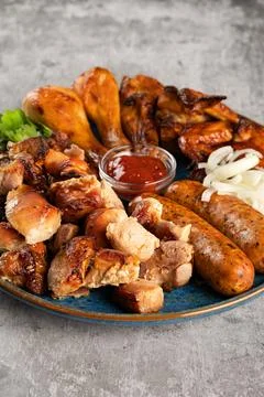 Various types of grilled meat in a plate on the table Stock Photos
