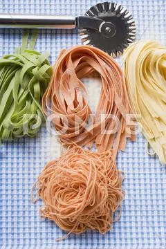 Various types of home-made pasta with pastry wheel Stock Photos