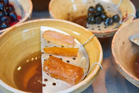 Various types of jam in ceramic vases on the showcase, fruit cooked in sugar Stock Photos