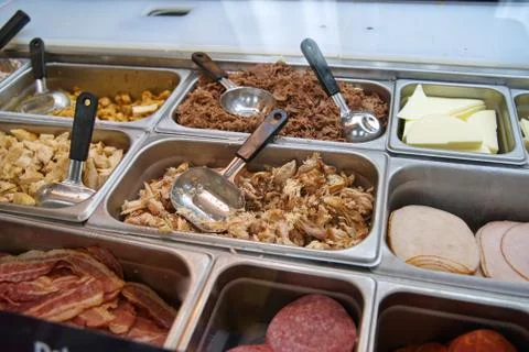 Various types of meats, cold cuts, and cheese at a sub sandwich eatery. Stock Photos