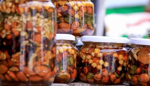 Various types of nuts in honey jars Stock Photos