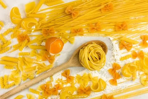 Various types of pasta on marble with egg Foto stock