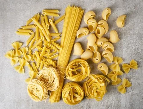 Various types of pasta on stone table, from above Stock Photos