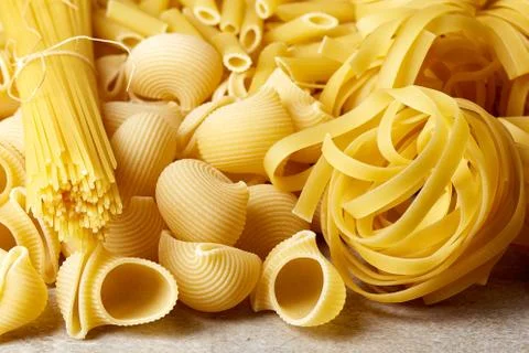 Various types of pasta on stone table Stock Photos
