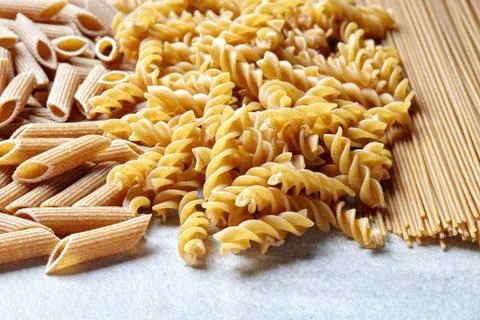 Various types of pasta on stone table Stock Photos