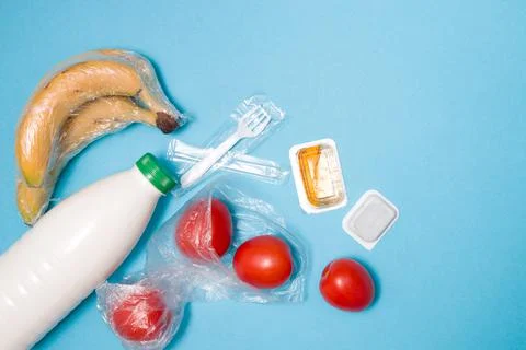 Various types of plastic packaging on a blue background, a bag of tomatoes, b Stock Photos