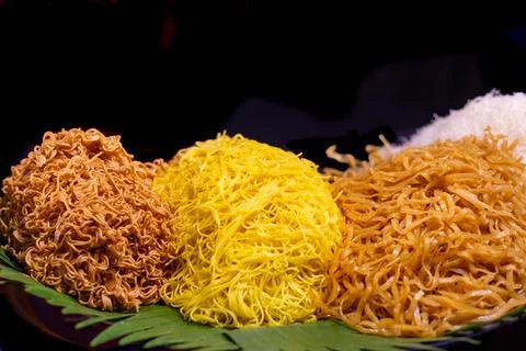 Various types of prepared noodles on table in stall at street market, black.. Stock Photos