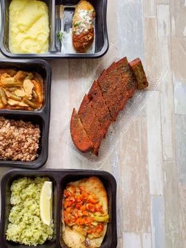 Various types of ready meals in disposable containers on the table Stock Photos