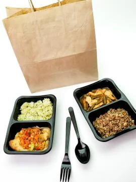 Various types of ready meals in disposable containers on the table Stock Photos