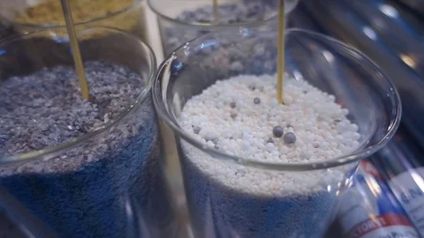 Various types of resin pellets and powders in glass containers Stock Footage 71568463