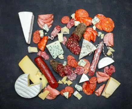 Various types of sausage and cheese on dark concrete background Stock Photos