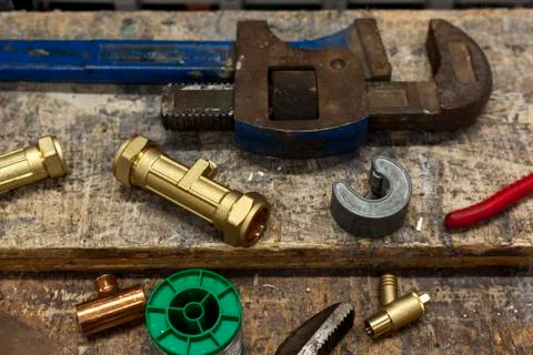 Various valves and wrenches on a plumbers workbench Stock Photos