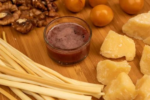 Various varieties of cheese, walnut kernels, smoked quail eggs and honey in a Stock Photos