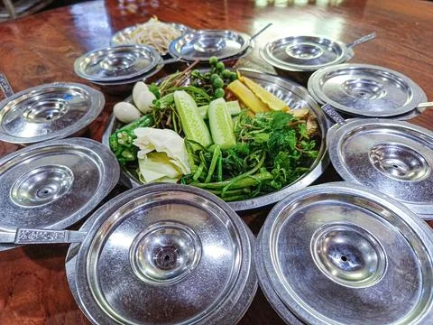 Various vegetables are placed in stainless steel dishes and put on the table. Foto stock