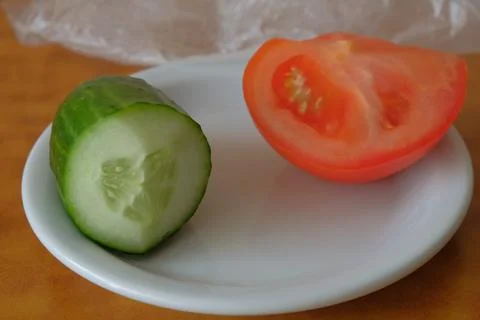 Various vegetables on a white background and plate tomatoes cucumbers shown Stock Photos