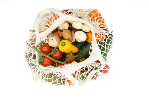 Various vegetables in white mesh net bag and isolated on white background Фото