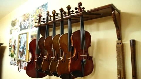 Various violins hanging from shelf in workshop Stock Footage 47747565
