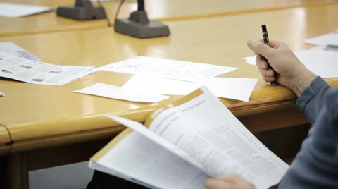 Varnished wooden table with documents and microphones, hand with pencil Video stock 64722000