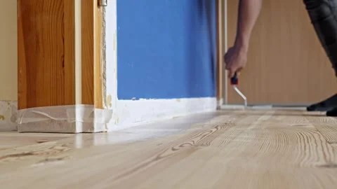 Varnishing Baseboard with Mini Roller Stock Footage 320993727