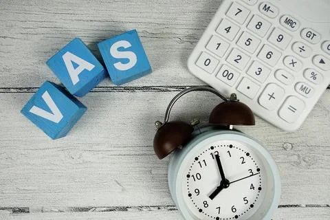 VAS (Value Added Services) text with alarm clock and calculator on wooden b.. 스톡 사진