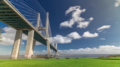 Vasco da Gama bridge timelapse hyperlapse with green lawn on a waterfront and Vídeo Stock 224341584