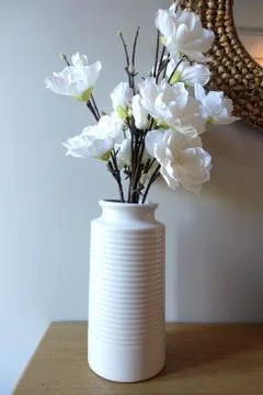 Vase of artificial flowers on side table in living room Stock Photos