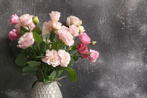 Vase with beautiful eustoma flowers on grey grunge background, closeup Stock Photos