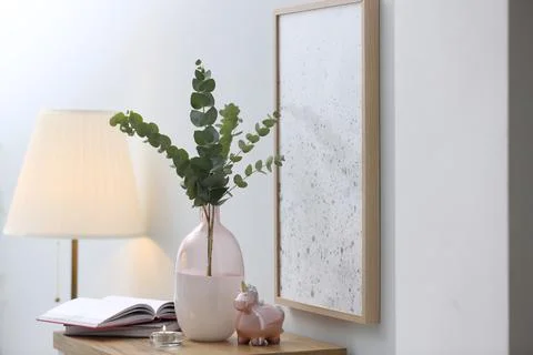 Vase with fresh eucalyptus branches on table in room. Interior design Stock Photos